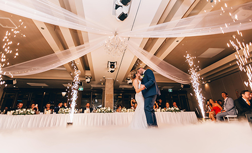 A couple dancing at a lavish wedding with fireworks going off