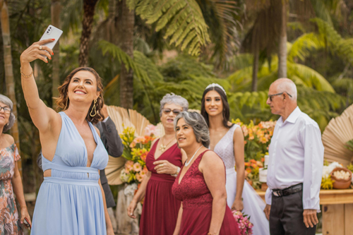 A wedding party taking a selfie with the bride on a cell phone.