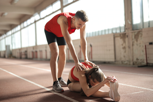 A married couple warms up before going on a jog together.