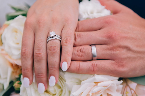 Close-up of manicured hands wearing wedding rings